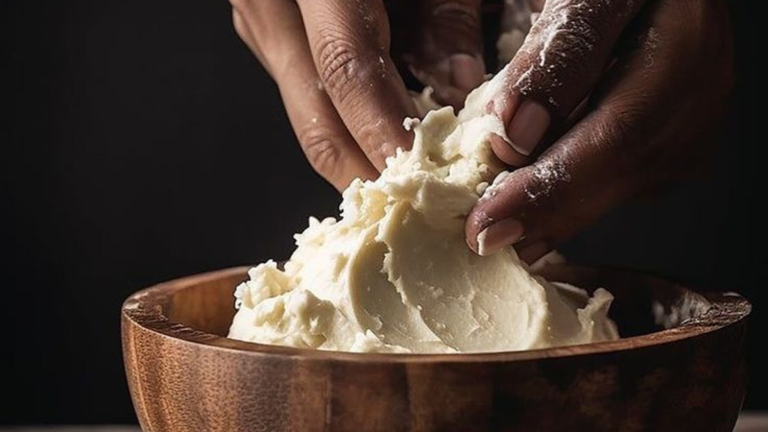 Shea butter in bowl with hands touching it