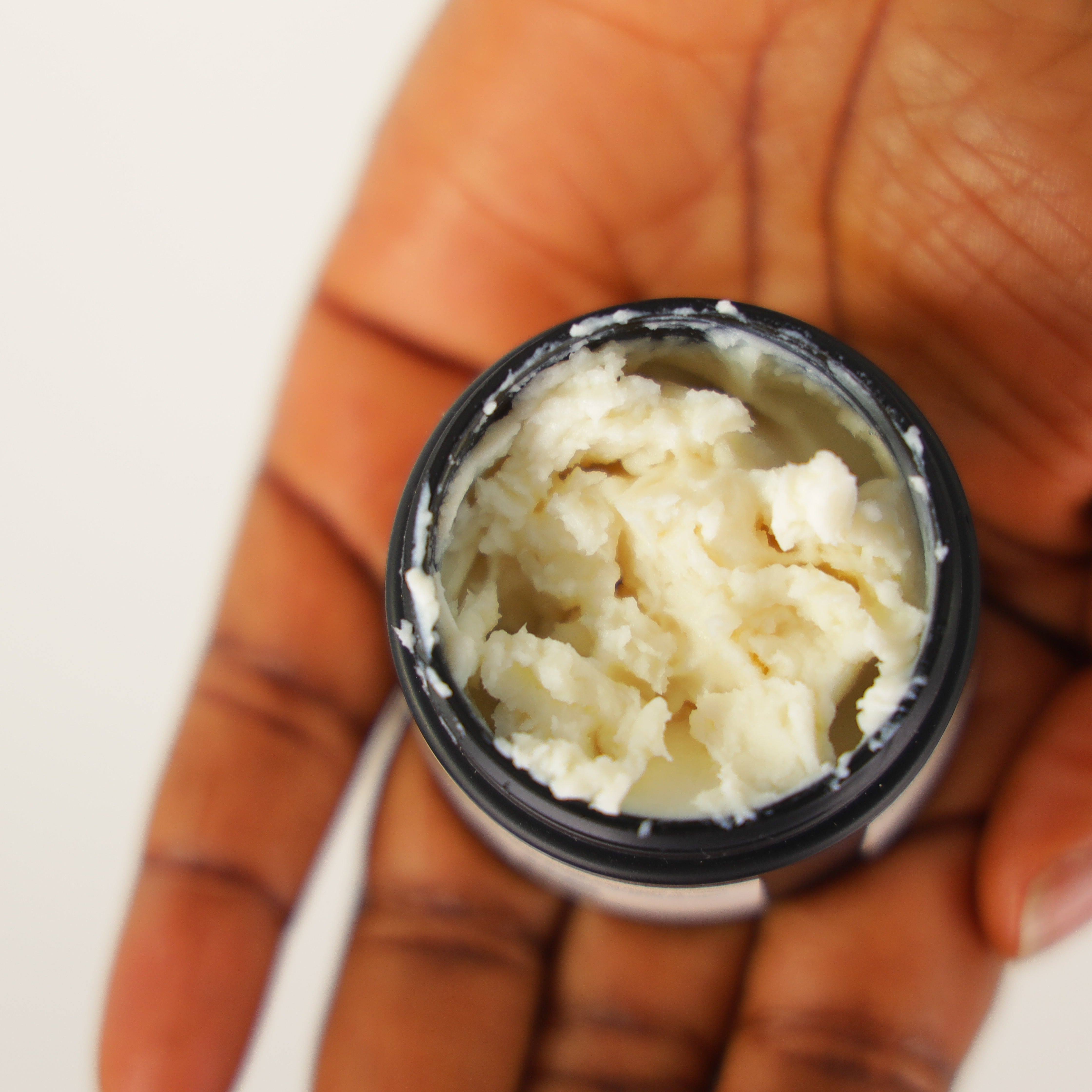 Open Jar of Stori of Africa Body Butter on a hand 