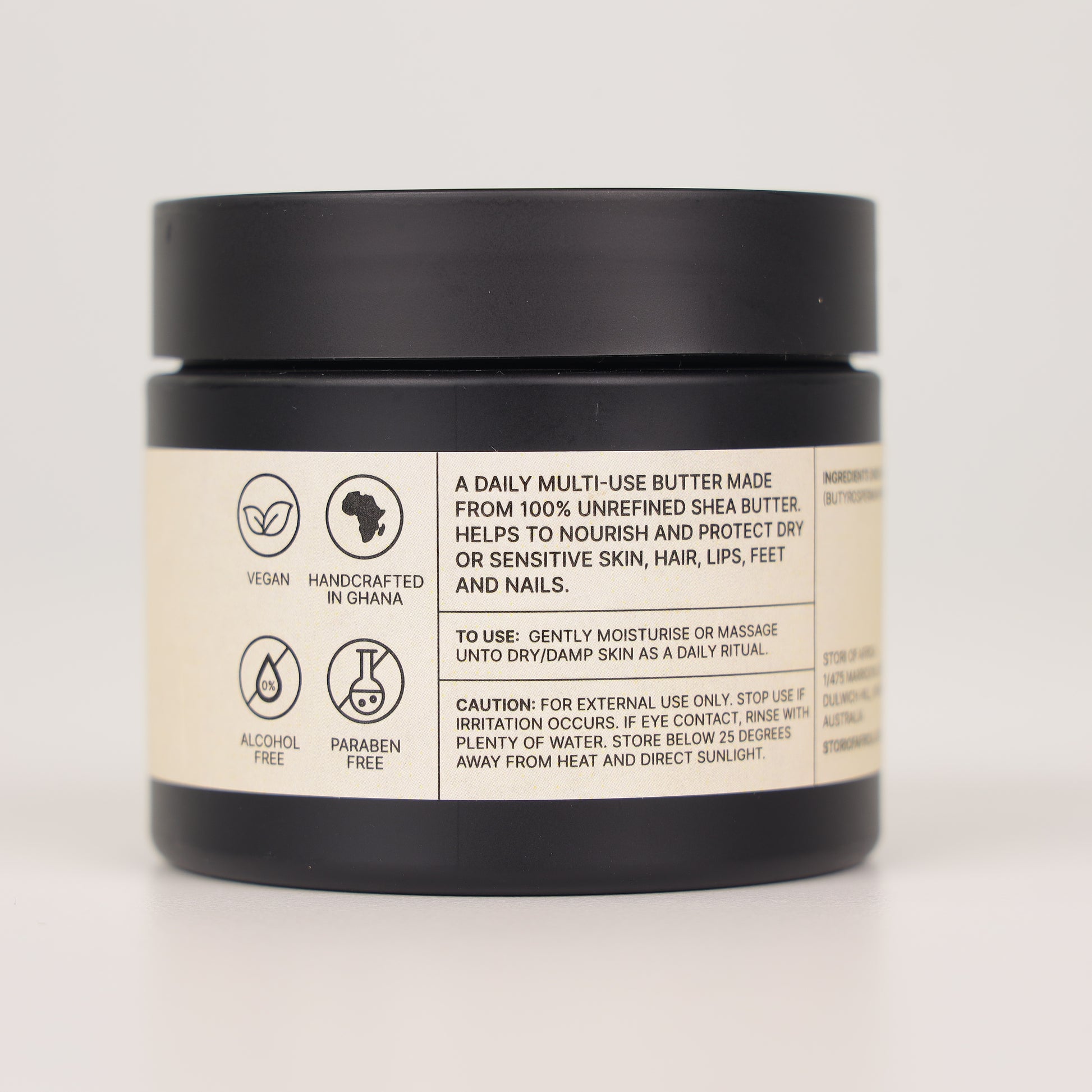 Jar of daily multi-use shea butter with label on a light gray background